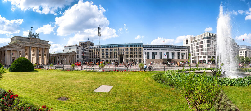 Berlin, Germany, 06/14/2020: Pariser Platz with Brandenburg Gate, French embassy and the academy of artson a sunny day in summer, in foreground a fountain and park