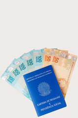 Brazilian Work Card (Carteira de Trabalho) with Brazilian money isolated on white background. Brazilian economy concept.