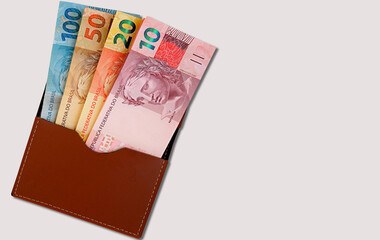 Wallet with Brazilian money isolated on white background. Brazilian Real banknotes. Salary and economy concept.