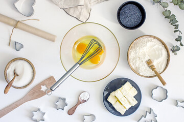 The process of making a poppy cake. Eggs in a bowl and a whisk. Beat the eggs until lather.Top view, flat lay. Step by step instruction. Step 2