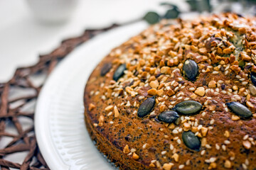 Homemade poppy seed pie with nuts on a light table, close-up