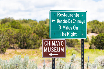 Naklejka premium Scenic drive during summer at High Road to Taos famous trip near Santa Fe with direction signs for Chimayo town village museum and restaurants in New Mexico