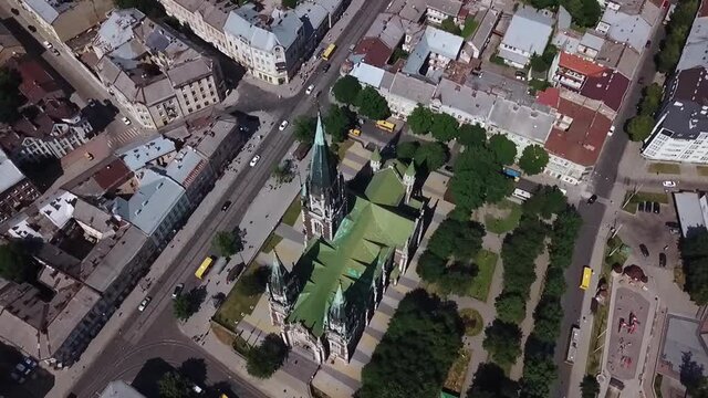 Old catholic church, street traffic life and buildings. Drone aerial video of Saint Olga and Elizaveta Church in central part of old city of Lviv, Ukraine. 