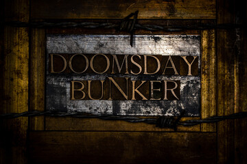 Doomsday Bunker text formed with real authentic typeset letters on vintage textured silver grunge copper and gold background