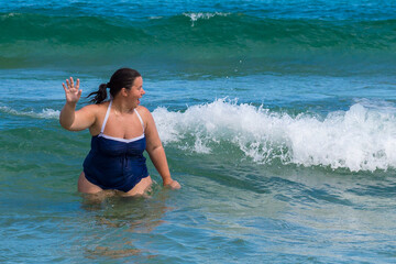 Body positive. Happy plump woman on the beach. 