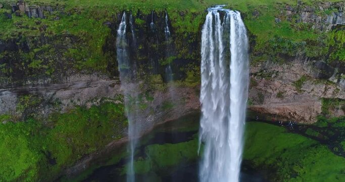 Iceland drone video aerial of famous waterfall Seljalandsfoss in Icelandic nature. Icon tourist attractions and landmark destination in Iceland nature landscape in South Iceland.
