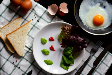 Culinary background with fried eggs in a pan, eggs, peas pepper on a white checkered tablecloth. Culinary concept. the process of cooking eggs. Illustration for cookbook.