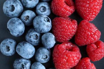 Background with ripe and bright raspberries and blueberries. Berry mix. Heart-shaped raspberries. Proper and healthy nutrition. Design for advertising and books of juices, jams, dessert. Ingredient.