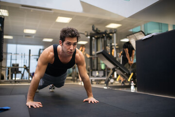 Obraz na płótnie Canvas Man doing push ups in a gym