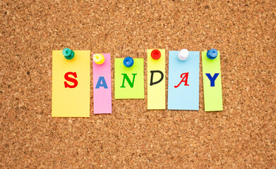 Multicolor notes with letters pinned on a cork notice board.