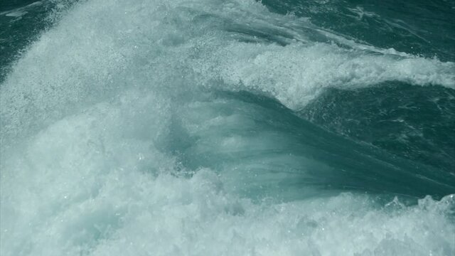 Energetic powerful stormy ocean waves. Open sea water with foam surf, side shot fly by and track in from drone above. Abstract natural background and texture.