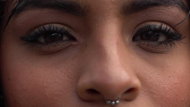 Close-up de ojos con mirada de mujer joven de piel morena mirando fijamente a la c&aacute;mara. Primer plano de mirada.