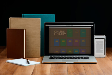 Books, laptop and mobile phone on wooden table