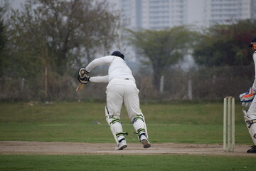 Full length of cricketer playing on field during sunny day, Cricketer on the field in action,...