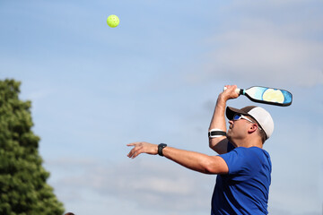 A pickleball overhead is hit during match