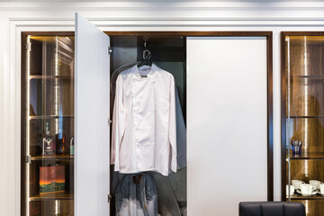 luxury barber shop interior, blue expensive furniture, wood trim, fashionable black ceiling, white robes on the backs of armchairs