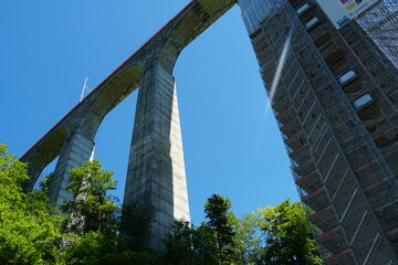 Viaduct railway bridge in upward perspective surrounded with fresh springtime nature and partly with scaffolding. The bridge is on St. Gallen bridge hiking trail in Eastern Switzerland.