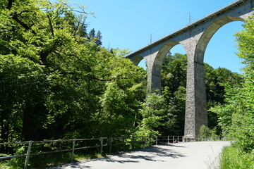 Fototapeta na wymiar Sitterviaduct railway bridge in lateral view and upward perspective. The bridge is on a St. Gallen hiking trail in Eastern Switzerland surrounded by mixed forests.