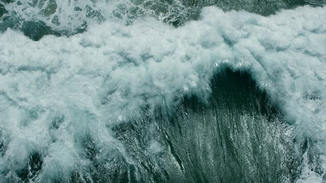 Vitality of blue energy and clear ocean water. Powerful stormy sea waves in top-down drone shot perspective.  Crashing wave line in Open Atlantic sea with foamy white texture.