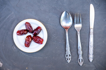 Kitchenware spoon and knife and fork with black gray background