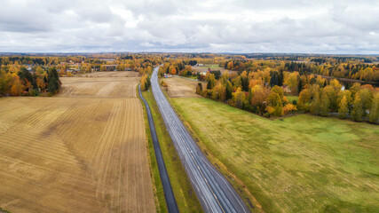 View of agricultural fields, autumn forest and road in Finland. Aerial panorama of beautiful farmlands.