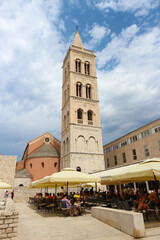 Obraz premium Zadar/Croatia-June 25,2018: Popular tourist square in front of magnificent Zadar cathedral and its gothic tower, popular landmark and example of beautiful, old architecture