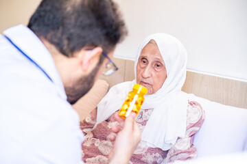 Old women and her doctor having conversation and explanation therapy details and medication dosage during house call medical check-up