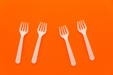 Four plastic disposable forks lying randomly