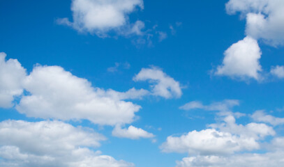 Naklejka na ściany i meble Fluffy clouds on a blue sky
