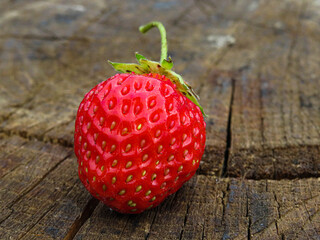 a bunch of ripe strawberries in a wooden bowl on the table