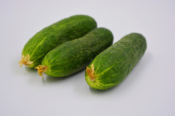 Young juicy cucumbers, Ukrainian cucumber harvest arranged on a white background. Fresh vegetables, healthy food for every day.