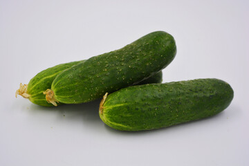Young juicy cucumbers, Ukrainian cucumber harvest arranged on a white background. Fresh vegetables, healthy food for every day.
