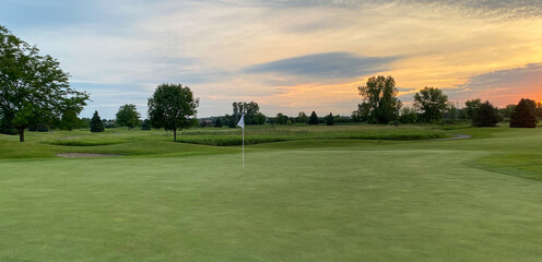Obraz premium sunrise over golf course green pond marsh
