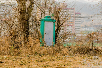 Green portable toilet with dirty white door
