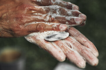 Close-up of a young Caucasian man washing his hands in a laver in the summer in the yard.