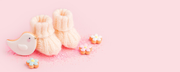 Baby shoes booties socks, baby shower decoration - sweet cookies on pink background, baby shower party concept, pregnancy, motherhood expectation, waiting, banner