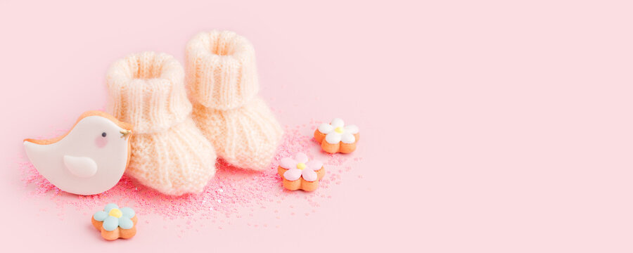 Baby shoes booties socks, baby shower decoration - sweet cookies on pink background, baby shower party concept, pregnancy, motherhood expectation, waiting, banner