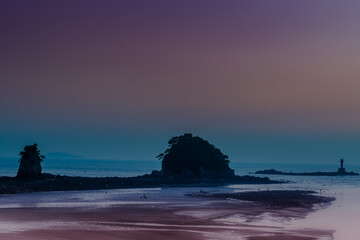 Fototapeta na wymiar Ocean islets and lighthouse during low tide.