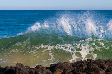 Spectacular, foaming white backwash from the Indian Ocean waves breaking on basalt rocks at Ocean...