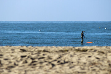 Fototapeta na wymiar paddle boarding on the ocean with beach