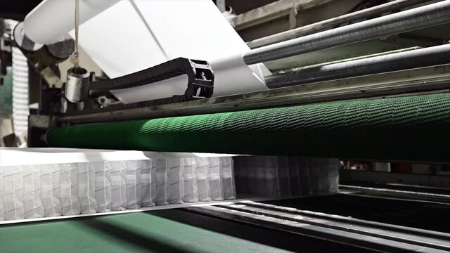 Machine transports a block of independent springs packed in a sheath, conveyor for the production of springs for mattresses,