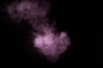 Purple powder explosion on black background. Colored powder cloud. Colorful dust explode. Paint Holi.