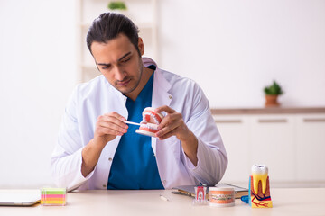 Young male dentist working in the clinic