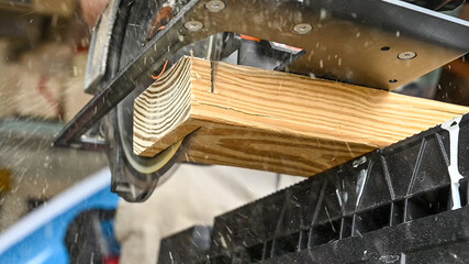 underneath view of a circular saw cutting through a pine board