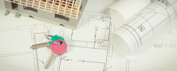 House under construction, home keys and electrical diagrams or blueprints, building home concept