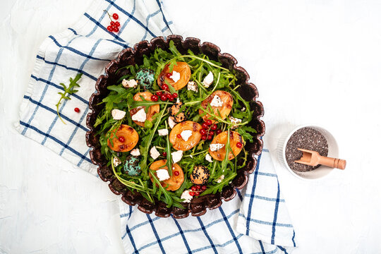 grilled apricot salad with arugula, berries, goat cheese on a wooden background. Food recipe background. space for text. top view