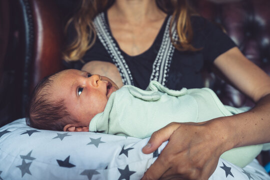 Young mother with baby on cushion at home