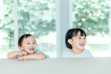 爽やかな白いリビングでカウンターに座る笑顔の子ども　kids house smile