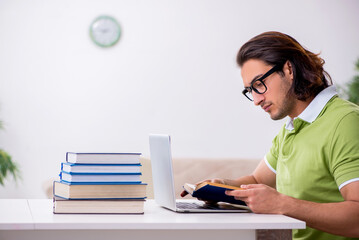 Young male student preparing for exams at home