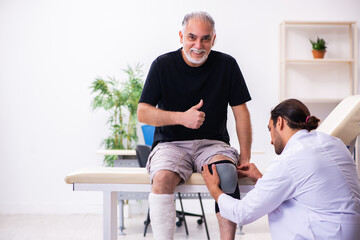 Old injured man visiting young male doctor traumatologist © Elnur